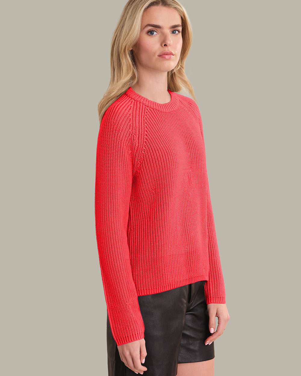 Woman wearing a red sweater against a neutral background