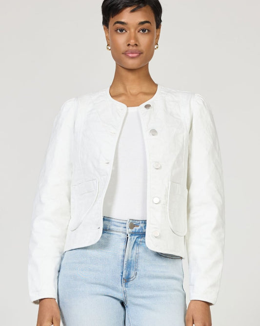 Person wearing a white jacket and light blue jeans on a plain background