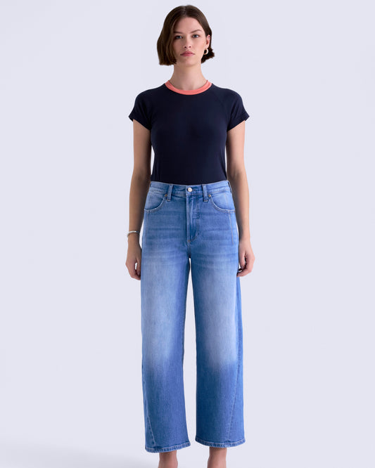 Woman wearing a black t-shirt and blue jeans on a white background