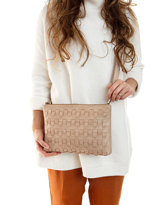 Person holding a Buff convertible crossbody clutch bag against a white background