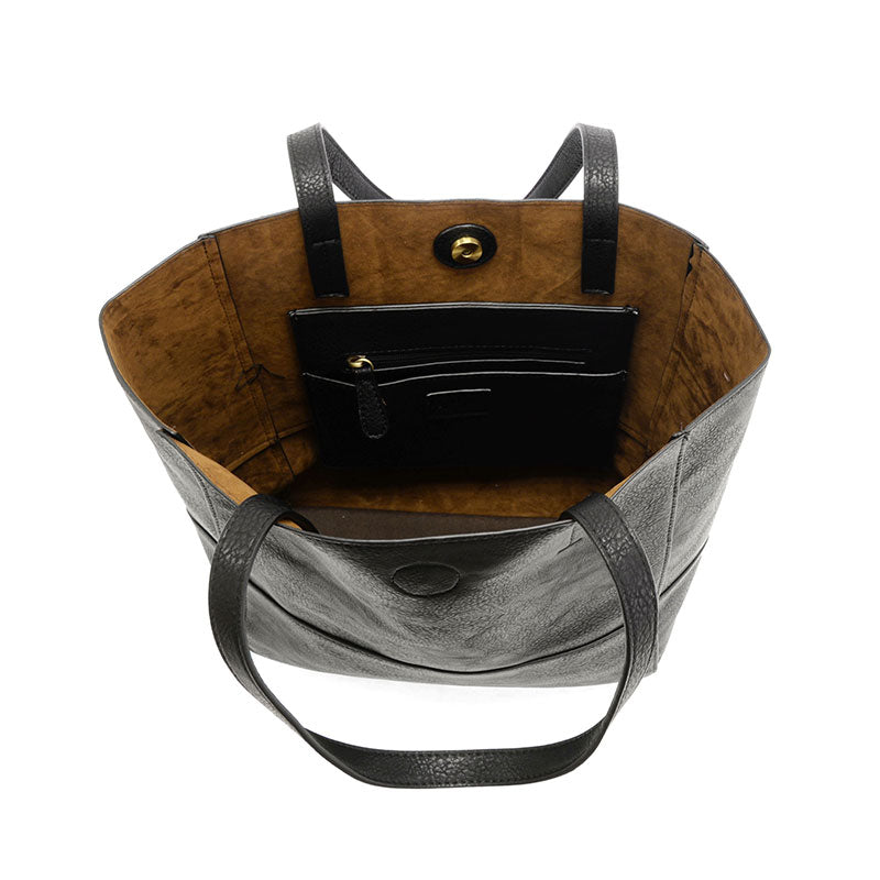 Black vegan leather raw edge tote opened against a white background.