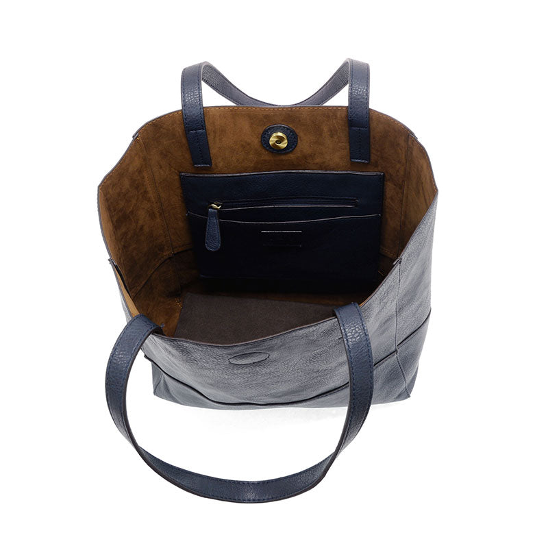 Black vegan leather raw edge tote opened against a white background.