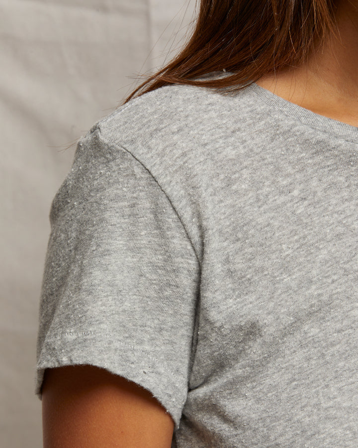 Gray t-shirt worn by a person on a neutral background