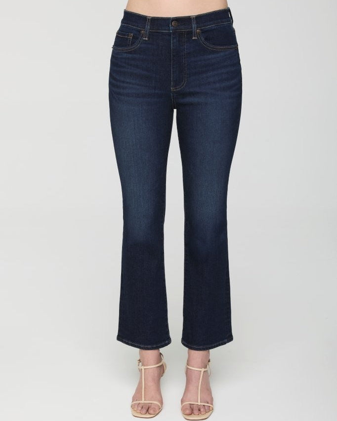Dark blue jeans worn by a person on a white background