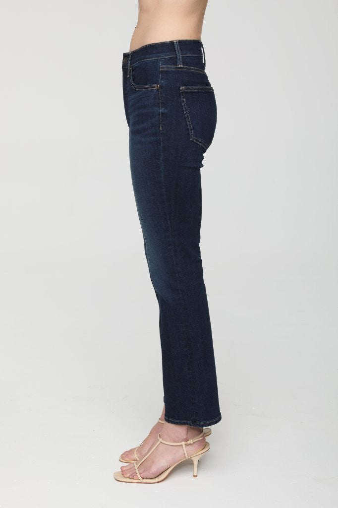 Dark blue jeans worn by a person on a white background