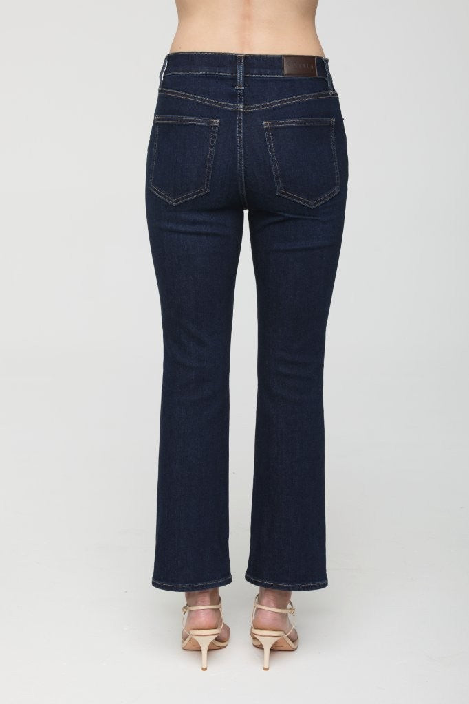 Dark blue jeans worn by a person on a white background