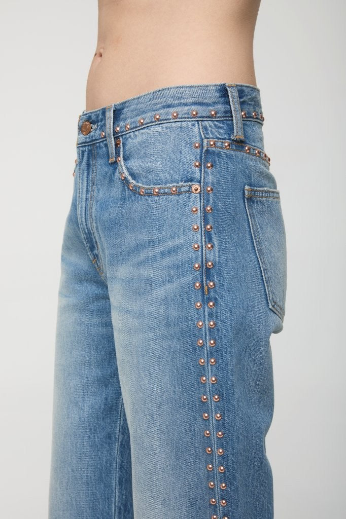 Blue jeans with decorative studs on a white background