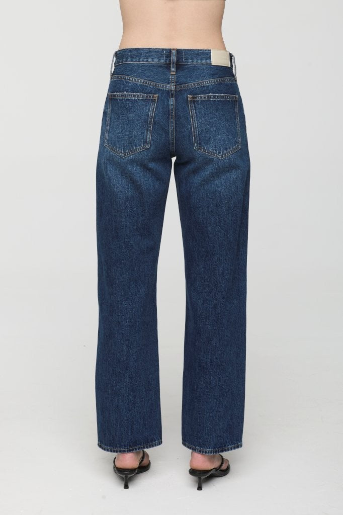 Blue jeans worn by a person on a white background