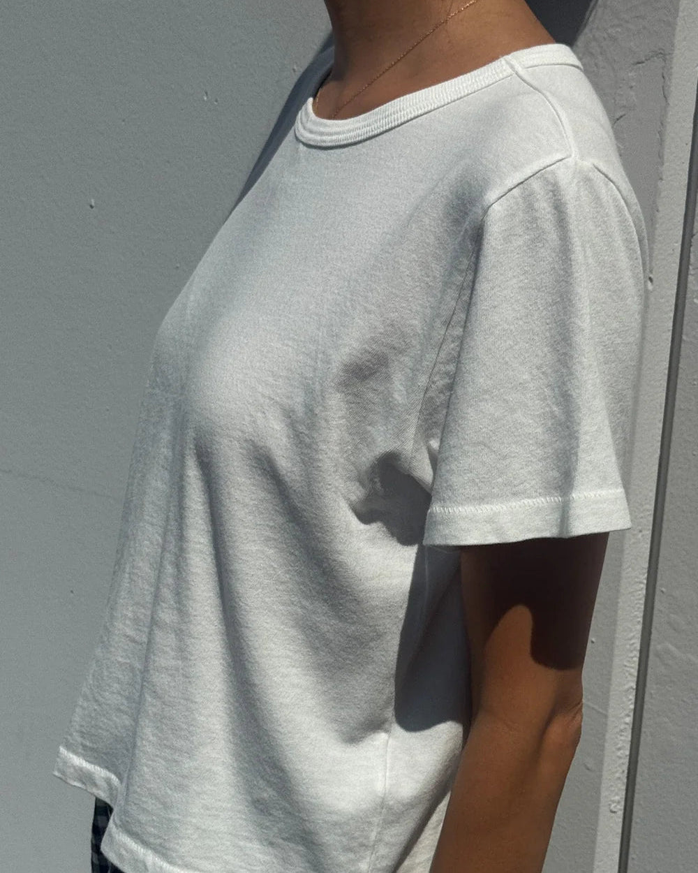 Person wearing a gray t-shirt against a plain background