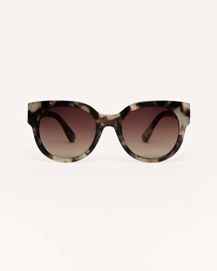Sunglasses with tortoiseshell frame and brown gradient lenses on a white background