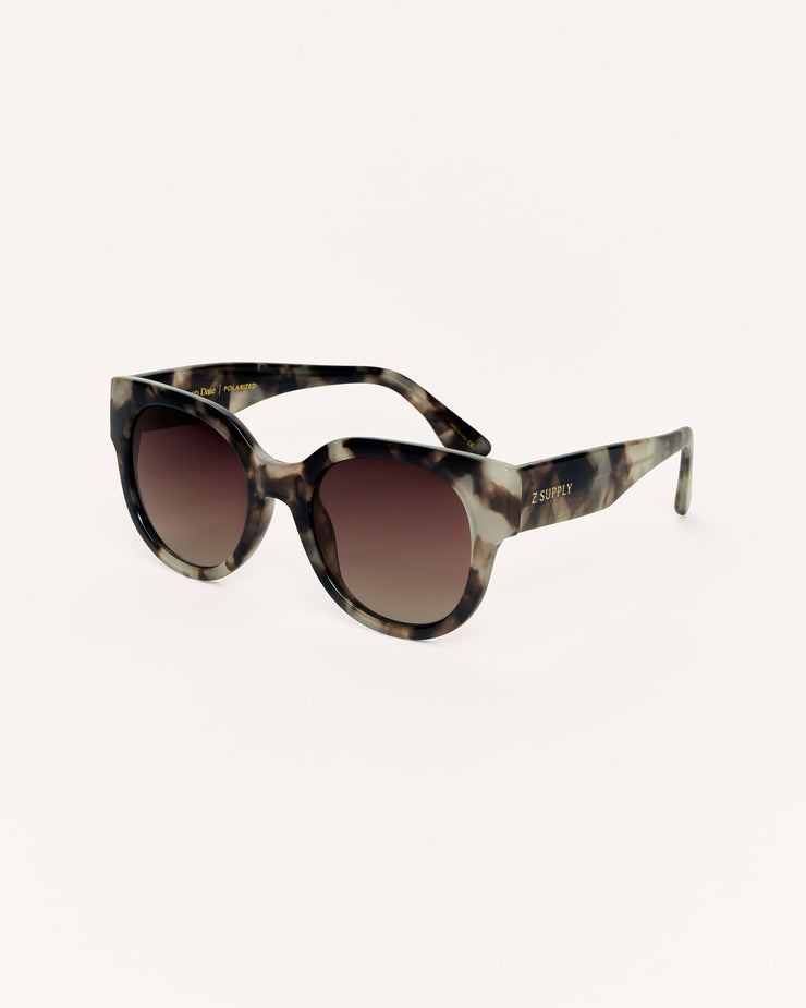 Sunglasses with tortoiseshell frame and brown gradient lenses on a white background