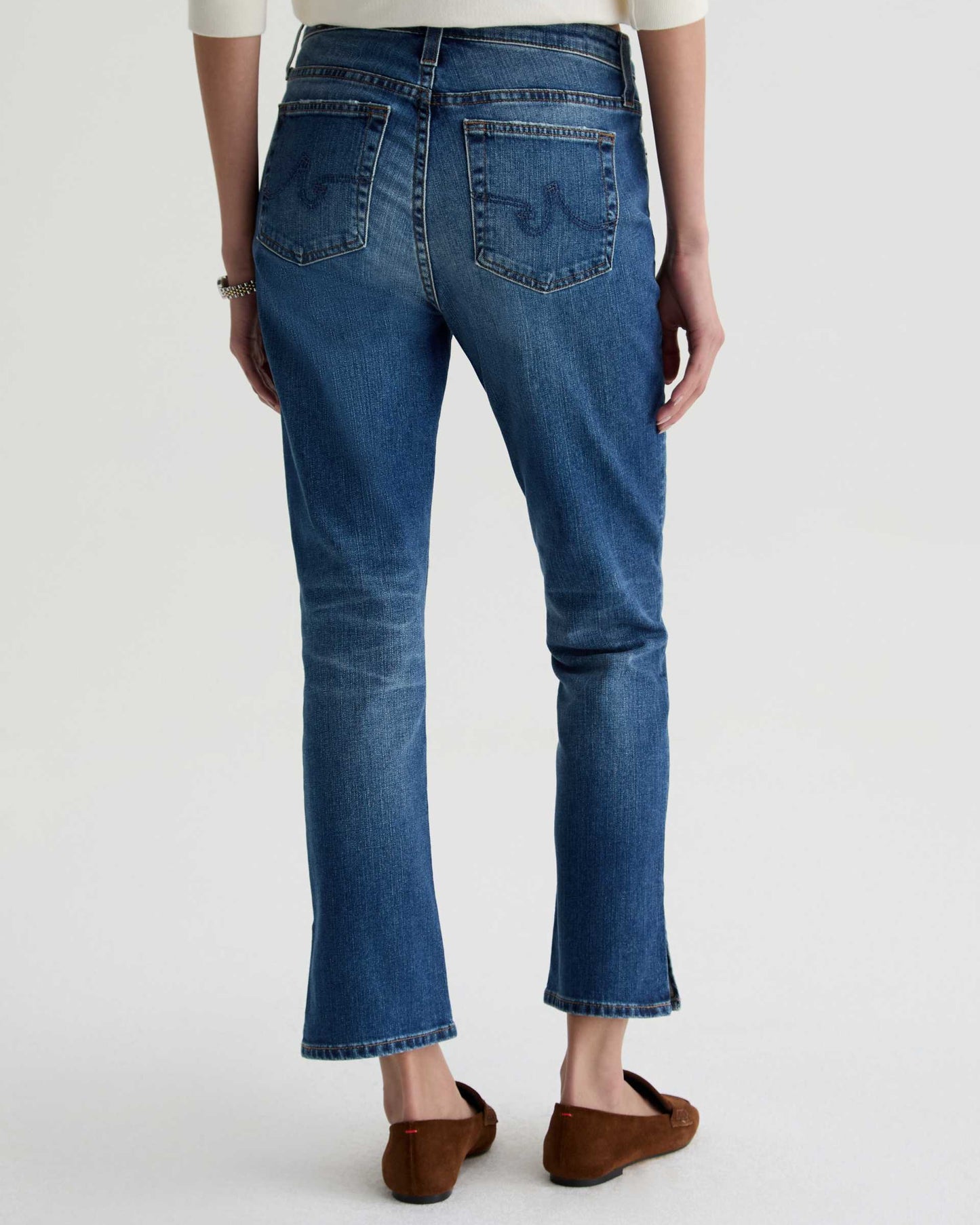 Person wearing blue jeans on a white background
