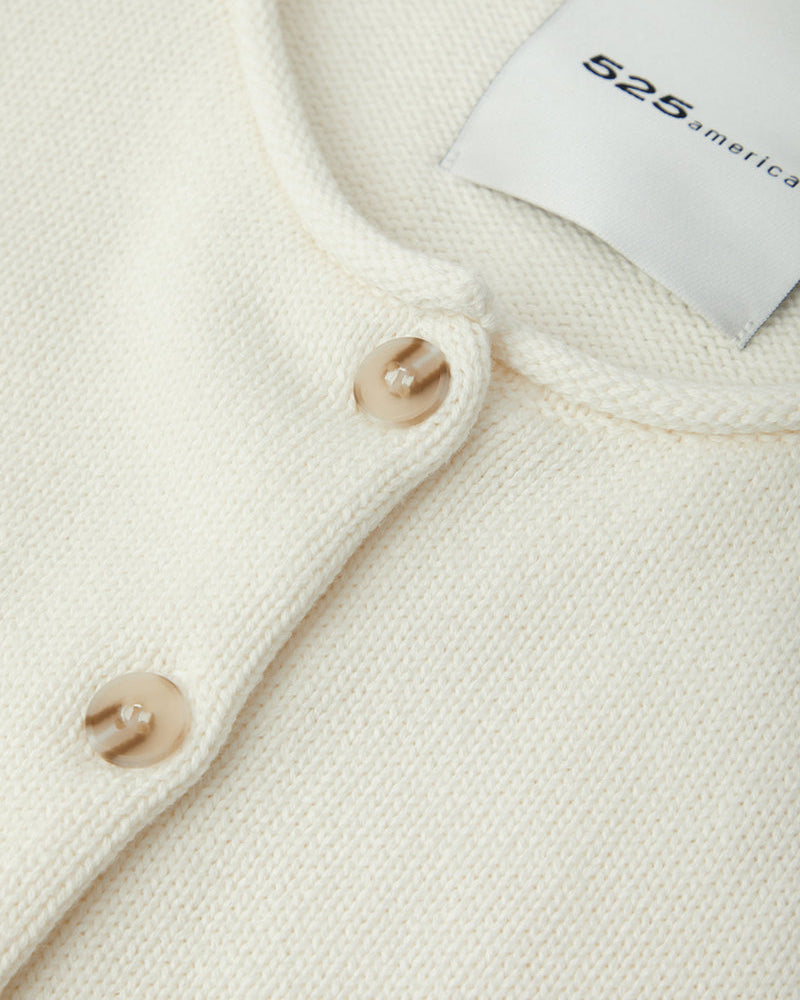 Close-up of a cream-colored garment with buttons and a tag displaying '525 America'.