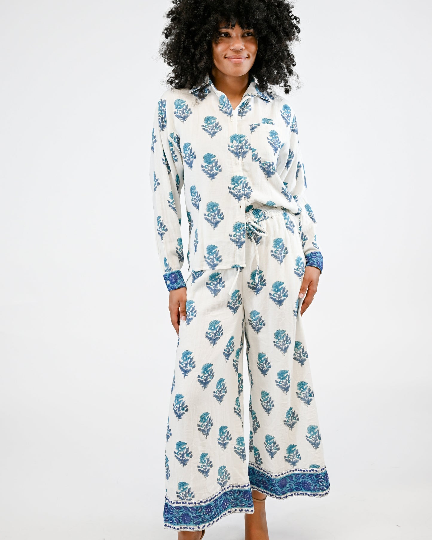 Woman wearing a white floral patterned outfit on a white background