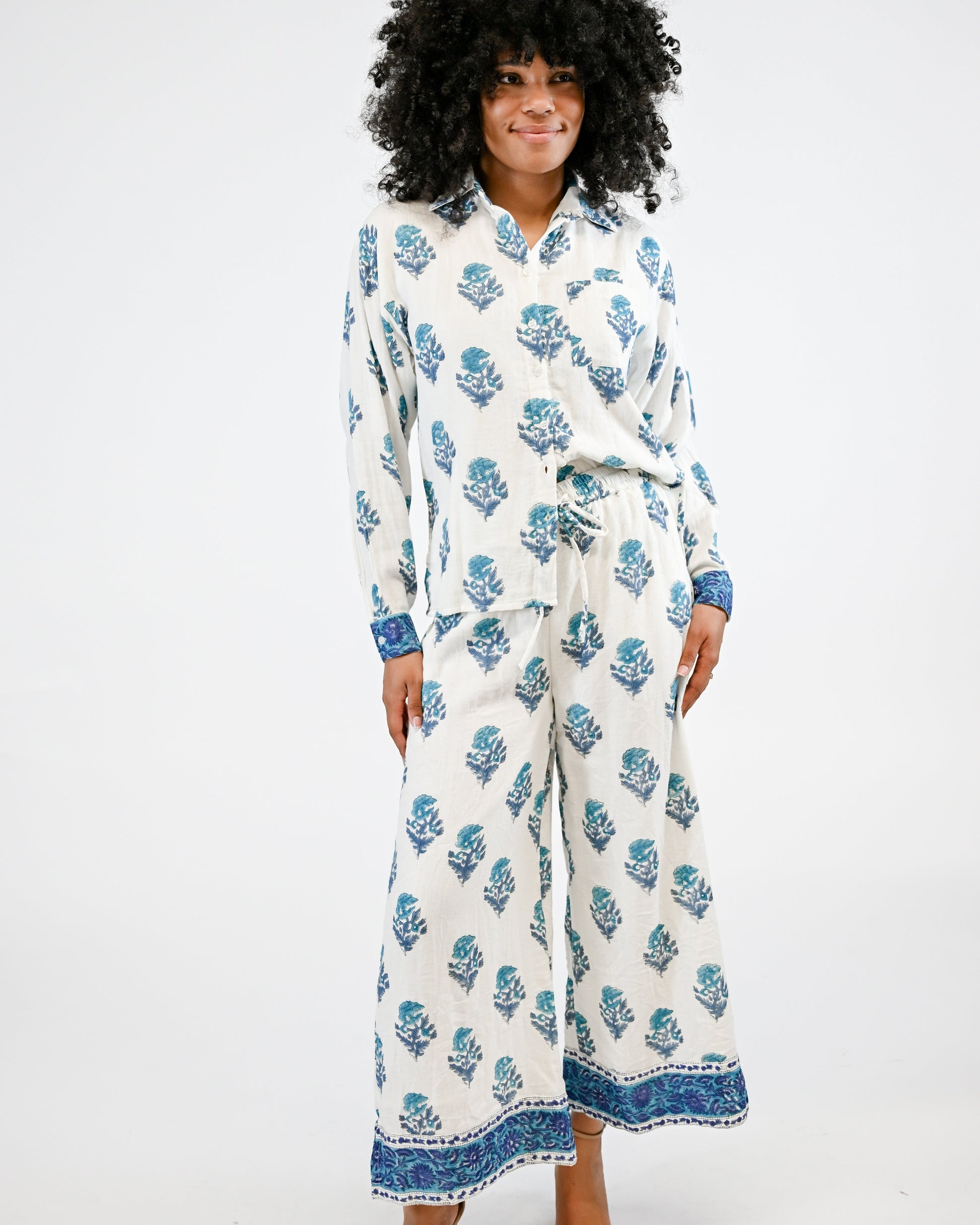 Woman wearing a white floral patterned outfit on a white background