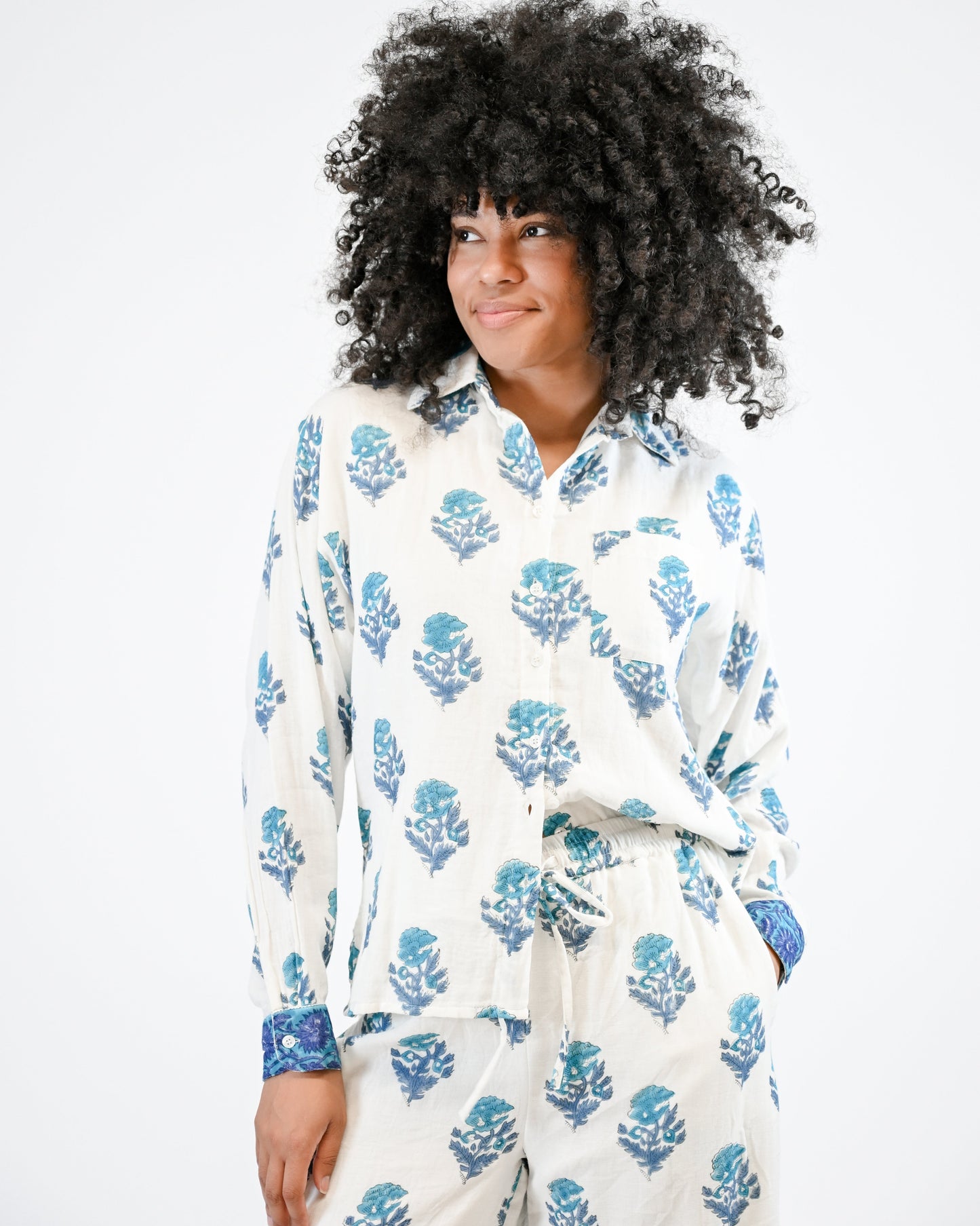 Person wearing a white floral pajama set on a plain background