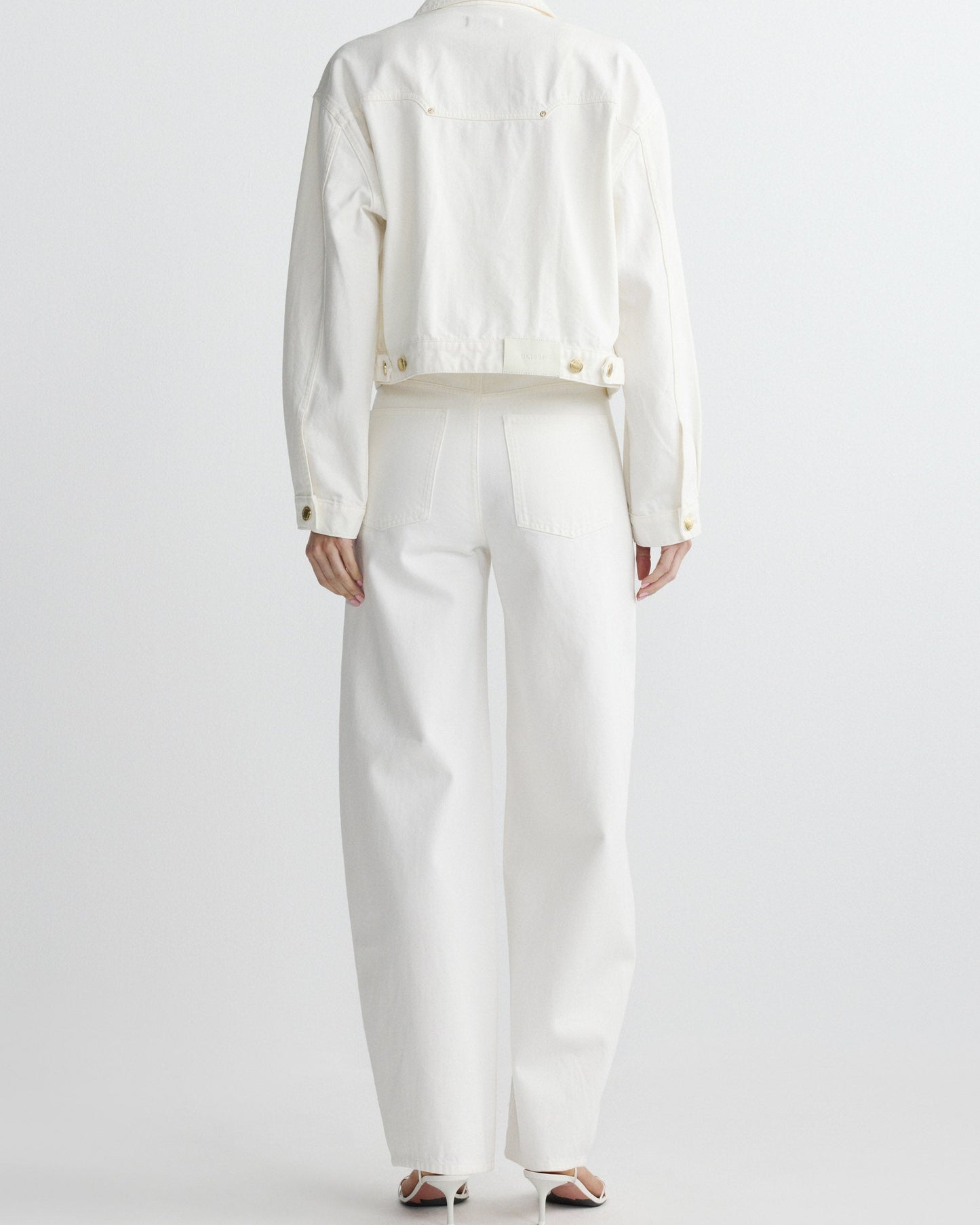 Person wearing a white outfit on a plain background
