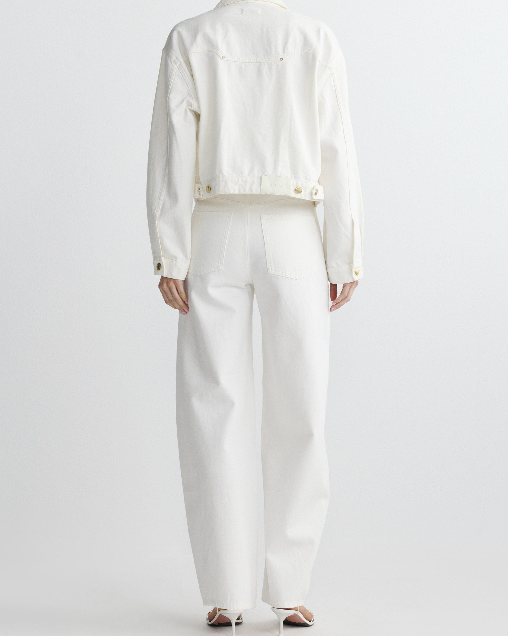 Person wearing a white outfit on a plain background