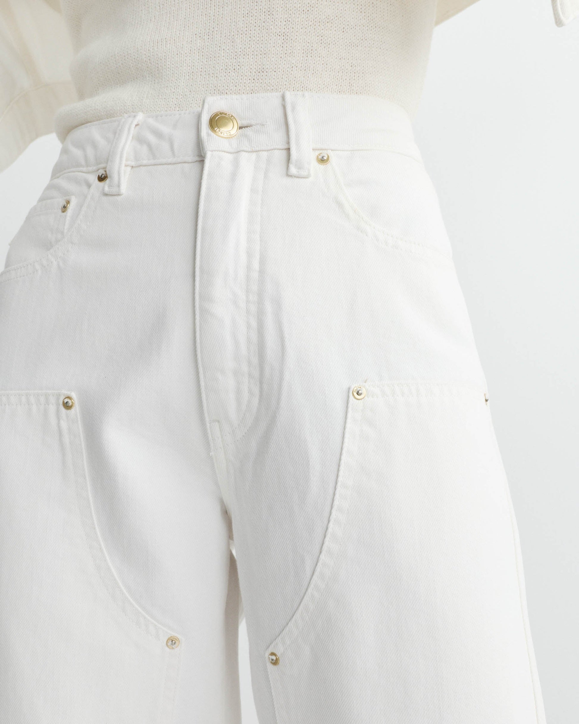 Close-up of white pants with gold buttons on a white background