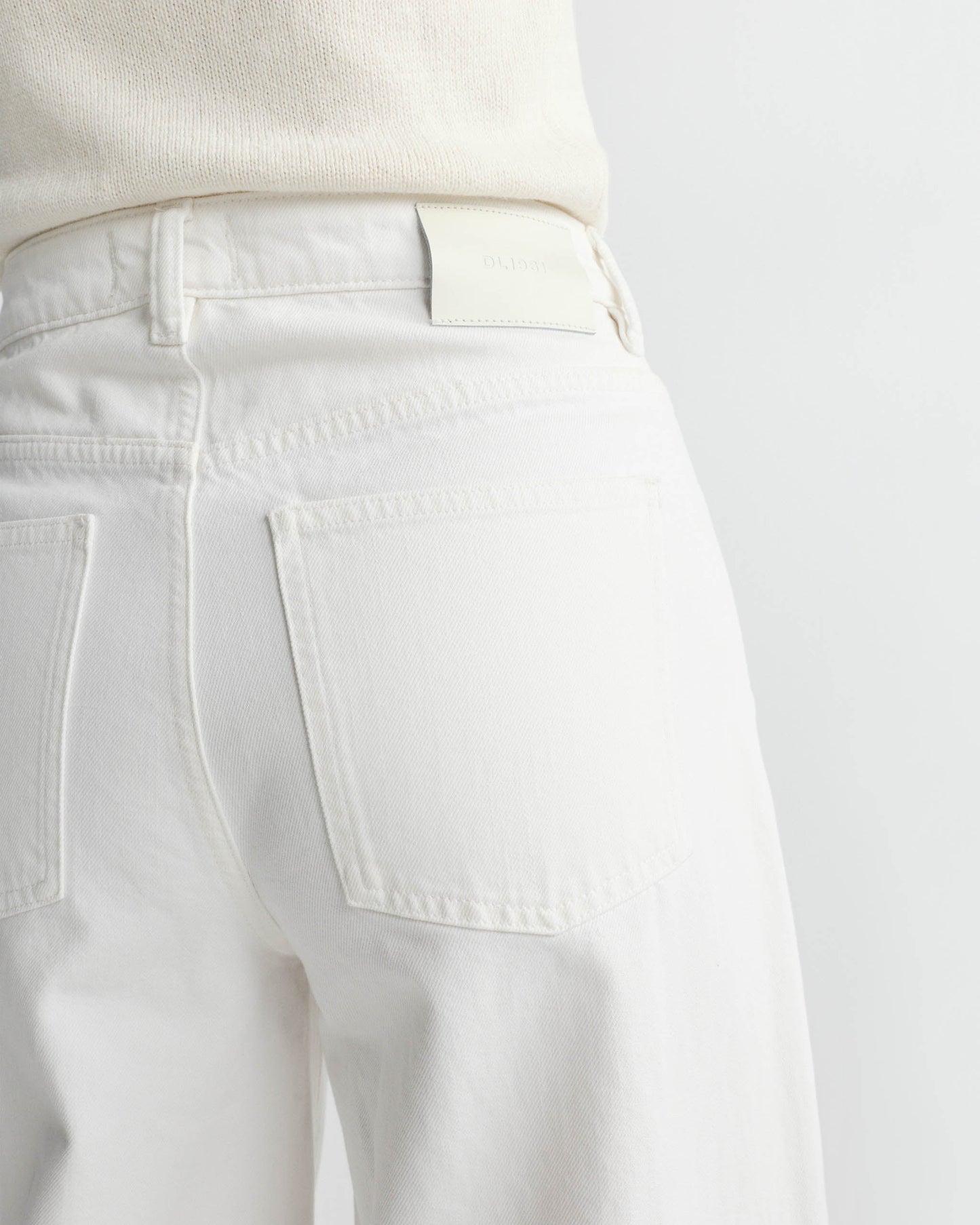 Close-up of white pants with a plain background