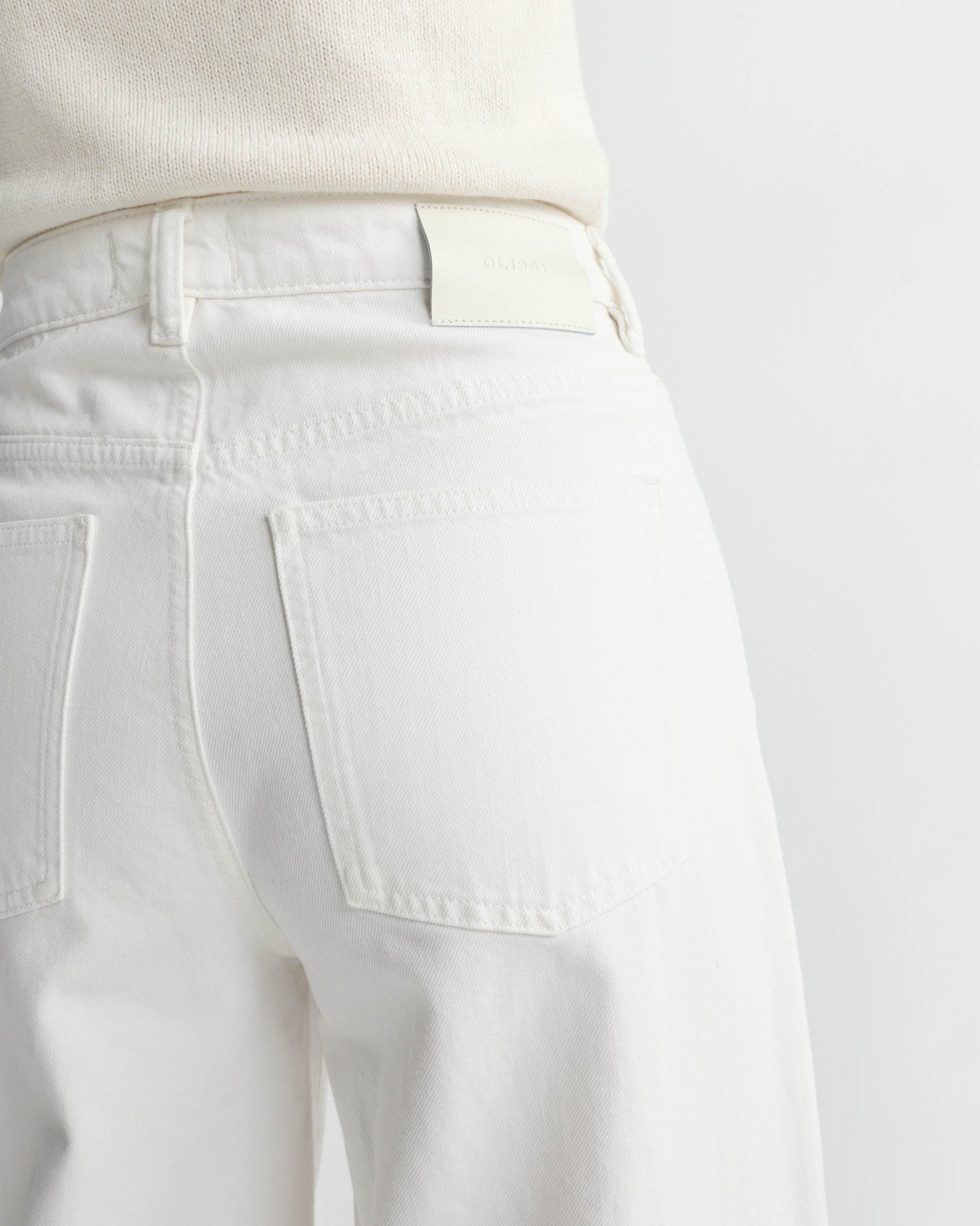 Close-up of white pants with a plain background