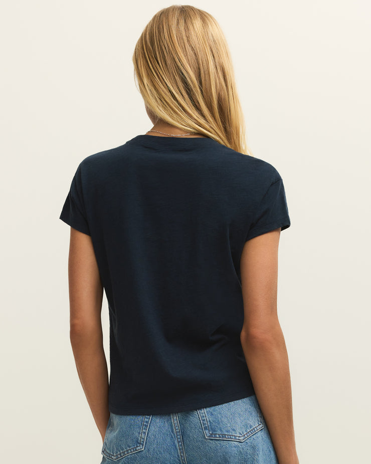 Person wearing a black t-shirt and blue jeans on a plain background