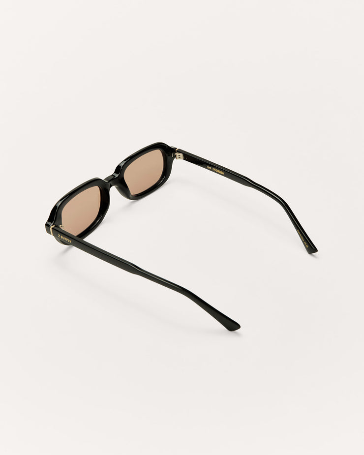 Sunglasses with black frame and brown lenses on a white background