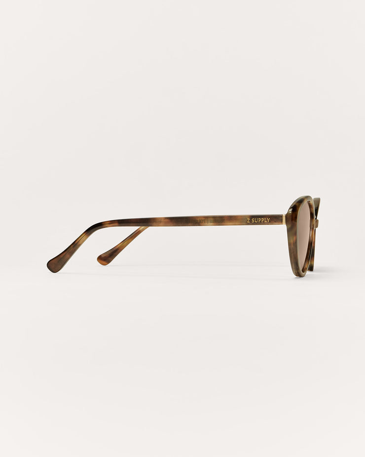 Tortoiseshell sunglasses on a light beige background