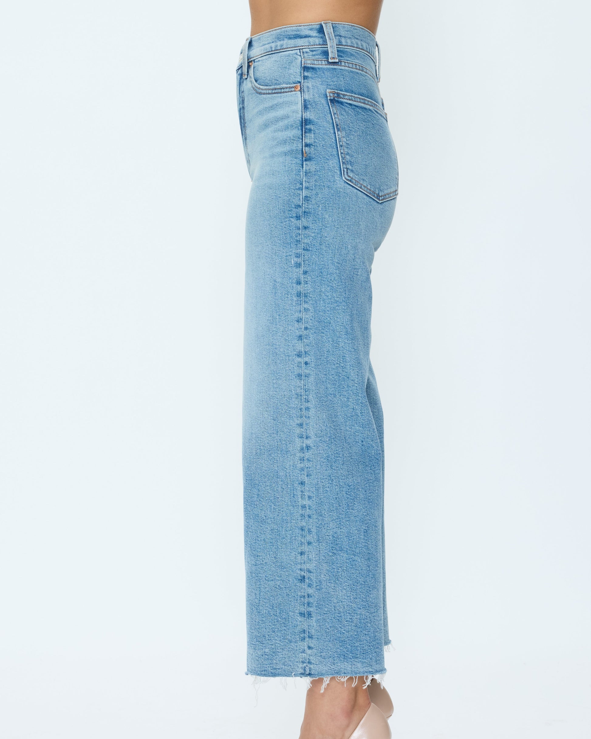 Light blue jeans worn by a person on a white background
