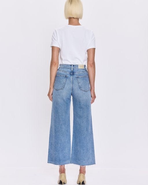 Person wearing a white t-shirt and blue jeans on a white background