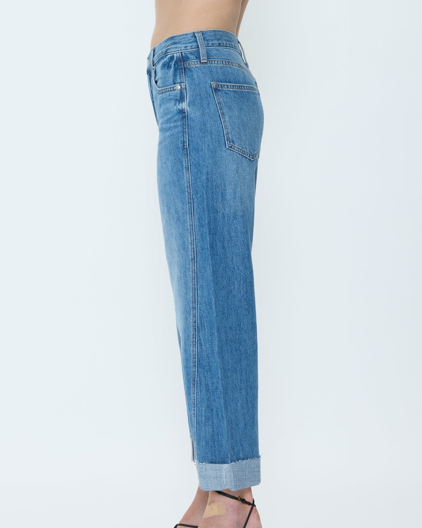 Blue jeans worn by a person on a white background