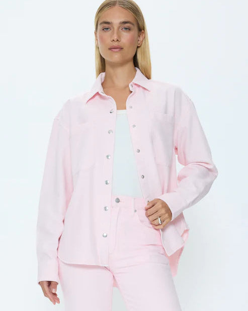 Woman wearing a pink denim set against a white background
