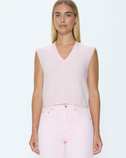 Woman wearing a light pink sleeveless top and pants on a white background