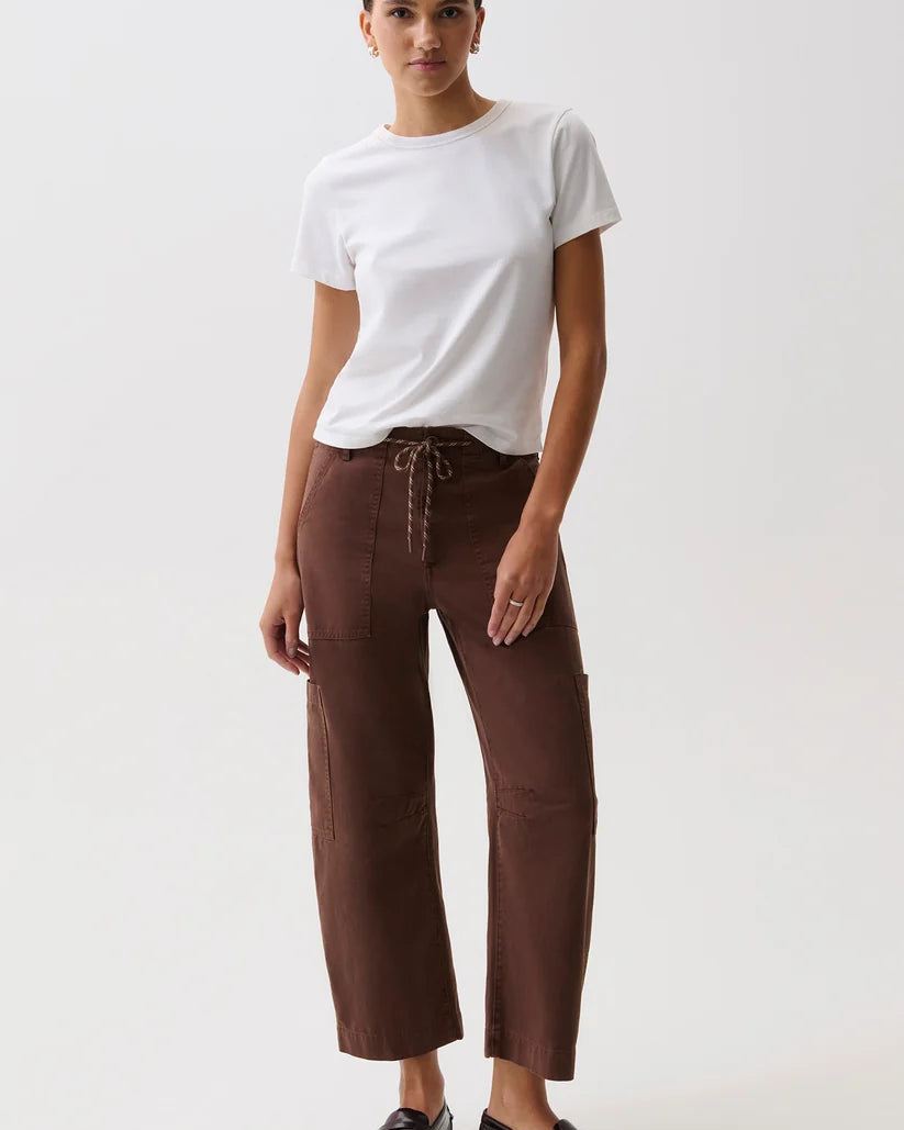 Woman wearing a white t-shirt and brown pants on a white background