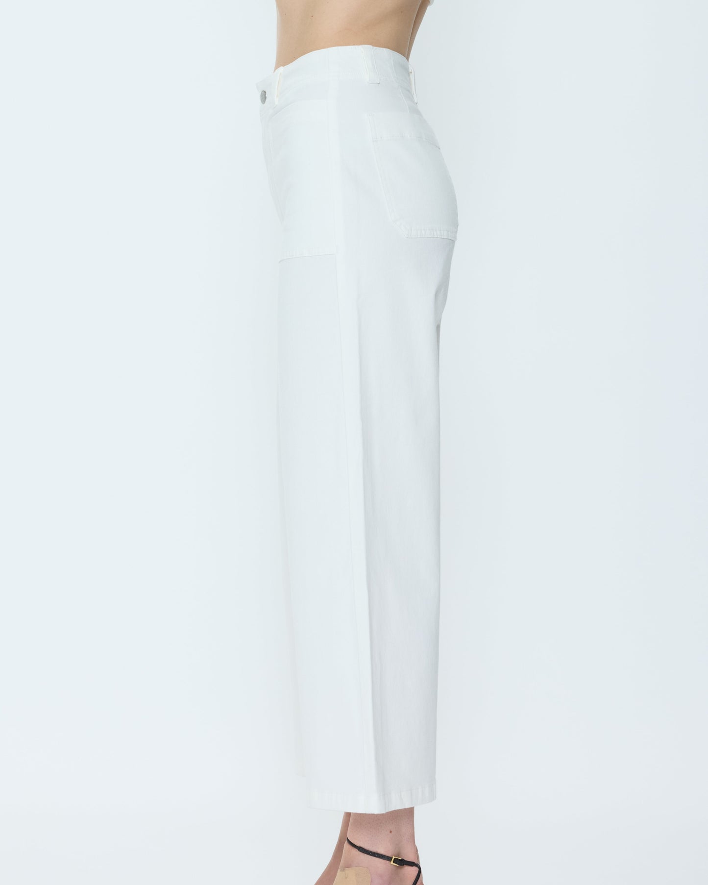 White pants with black strappy high heels on a white background