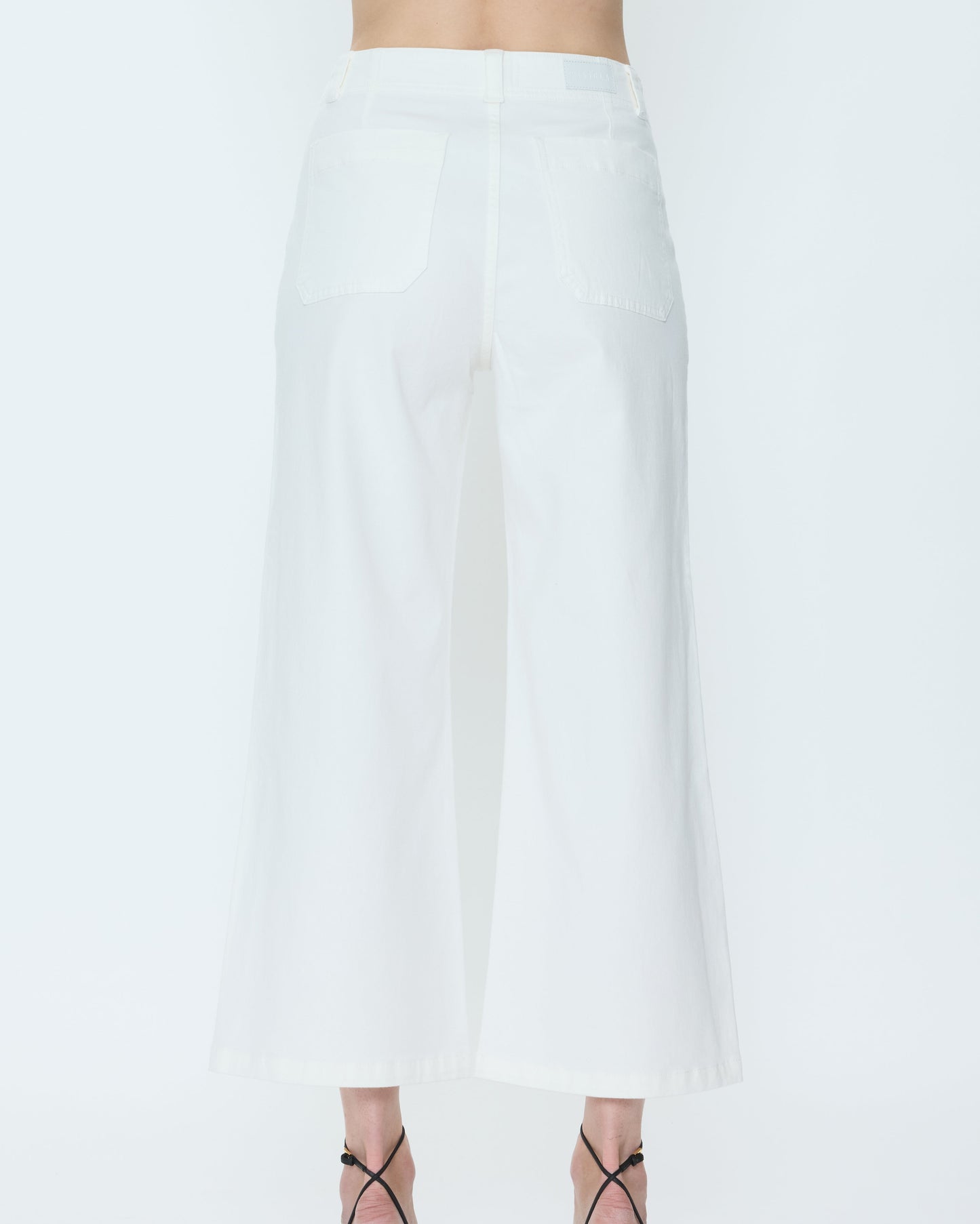 White pants worn by a person on a white background
