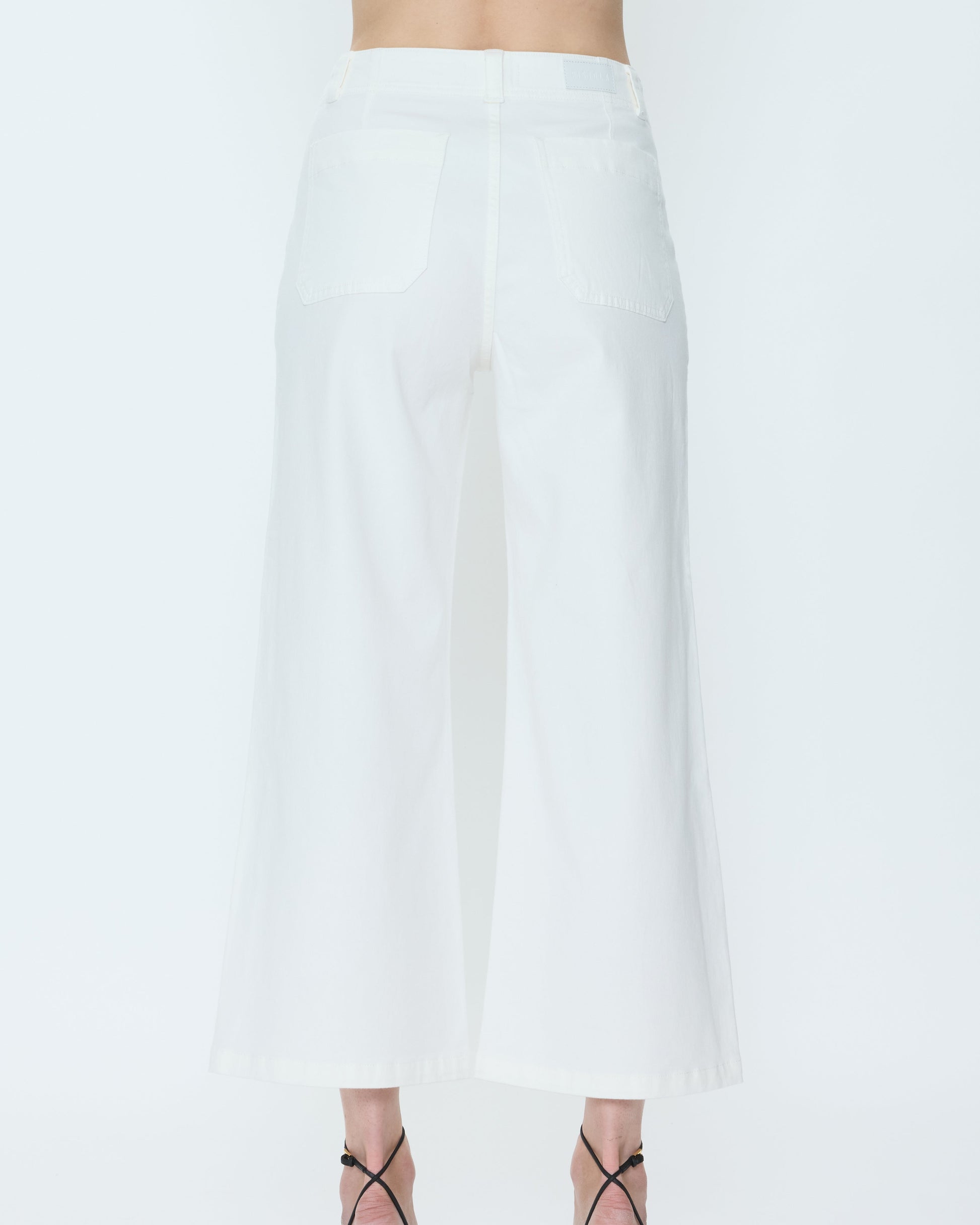 White pants worn by a person on a white background