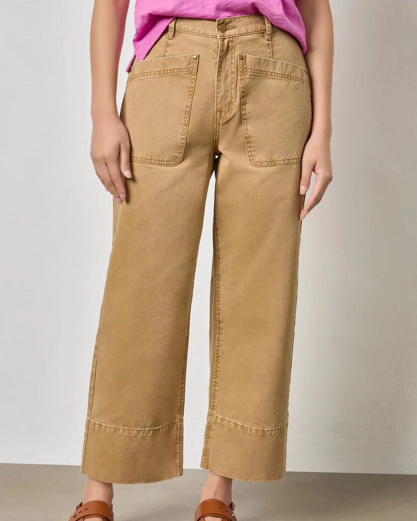 Person wearing beige wide-leg pants and a pink top on a plain background