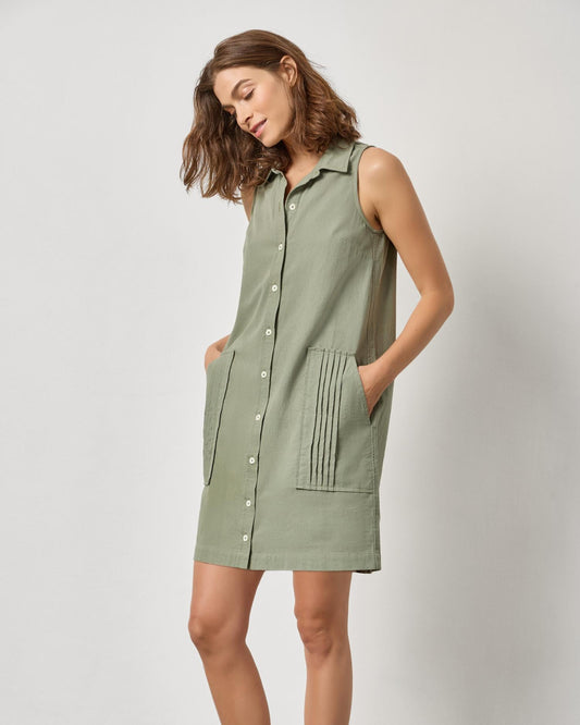 Woman wearing a green sleeveless dress against a white background