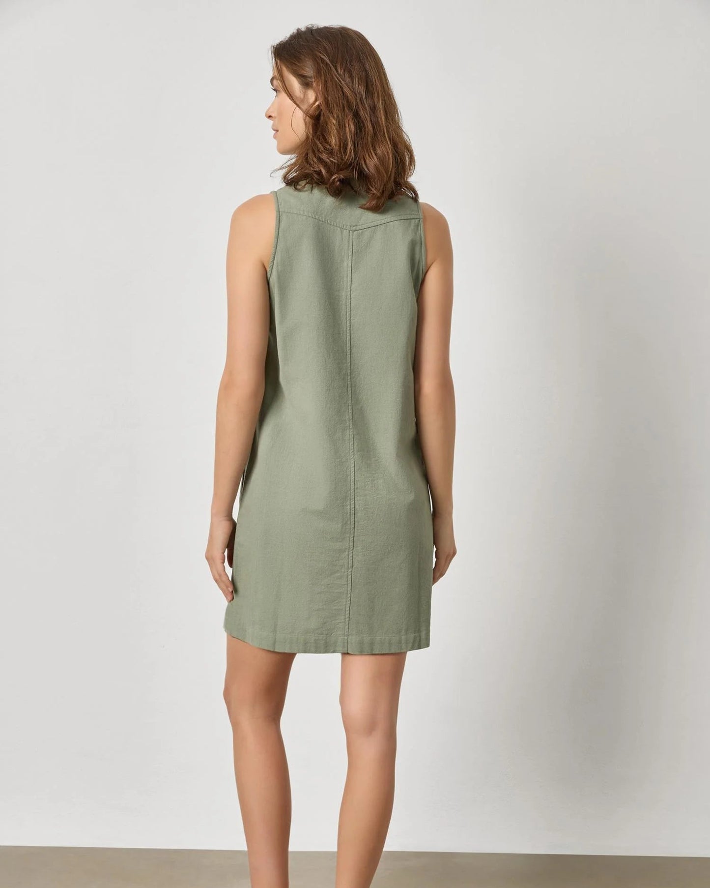 Woman wearing a green dress against a plain background