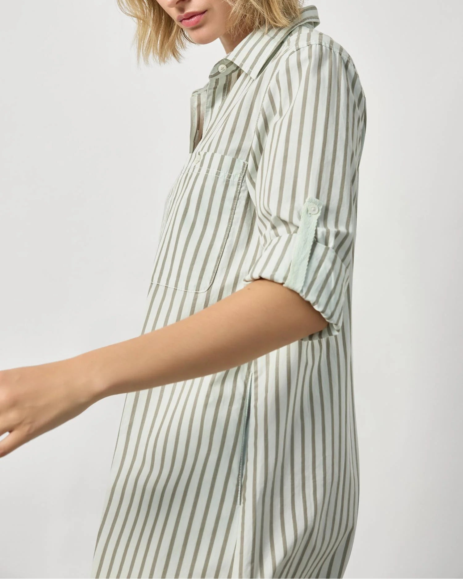 Woman wearing a striped shirt against a plain background