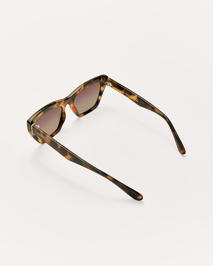 Sunglasses with tortoiseshell frame and brown lenses on a white background