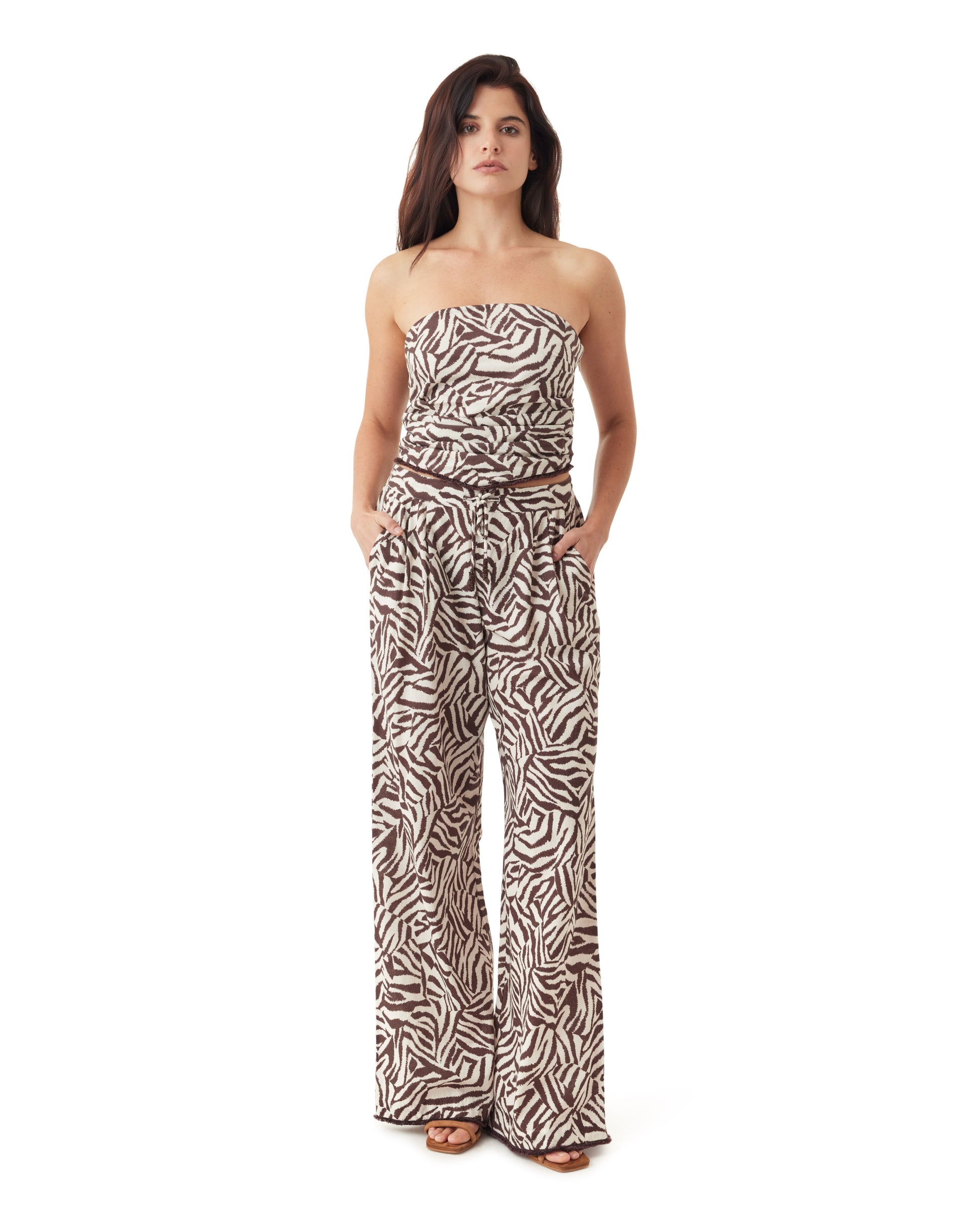 Woman wearing a strapless zebra print jumpsuit on a white background