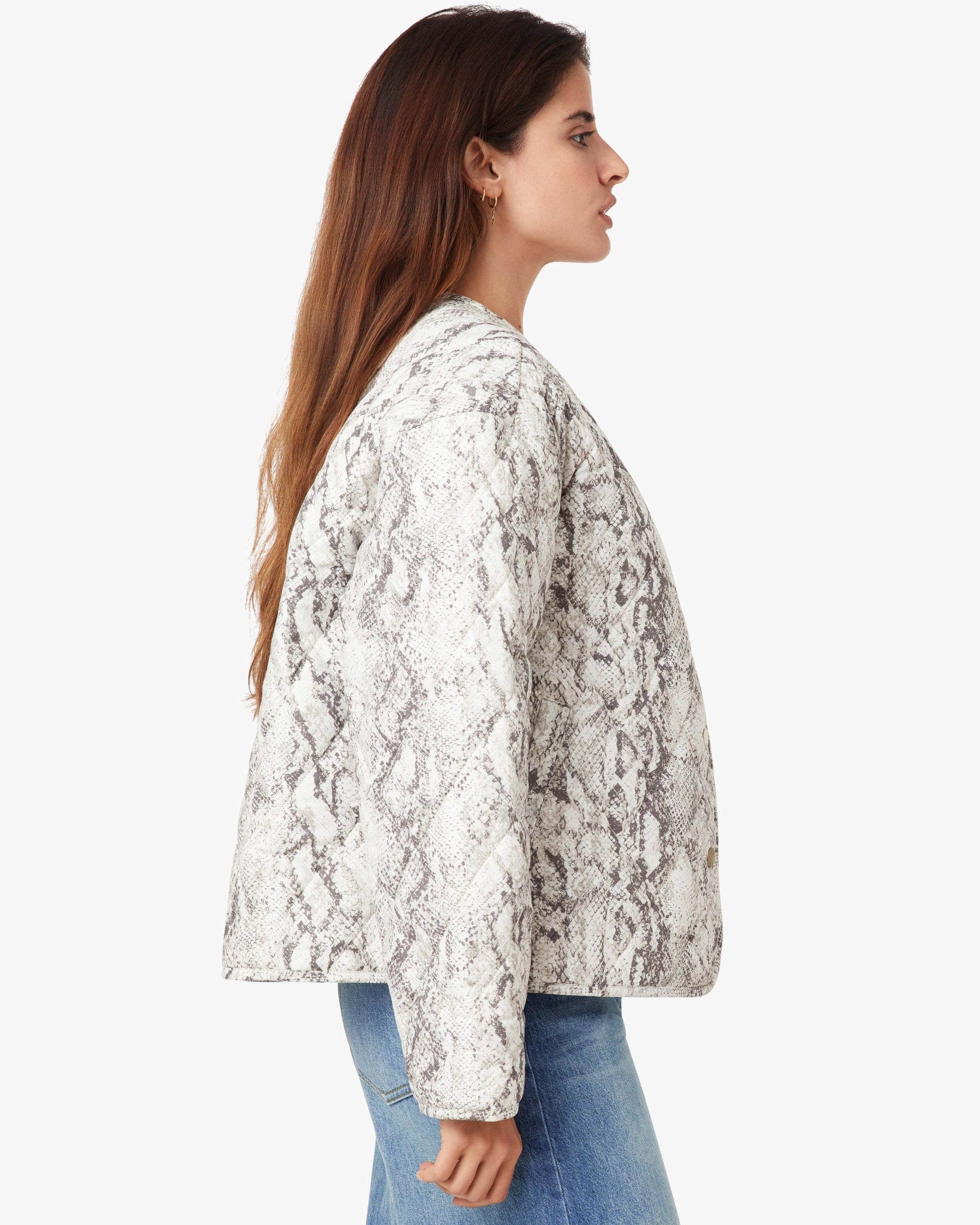 Woman wearing a snake print jacket on a white background