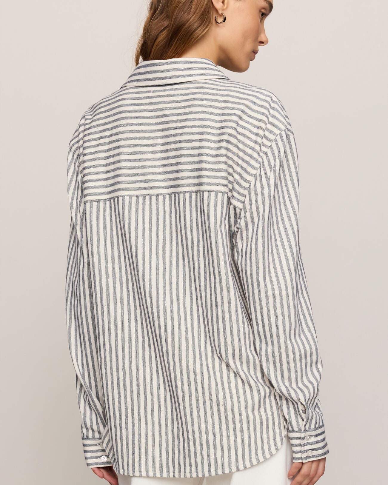Woman wearing a striped shirt against a plain background