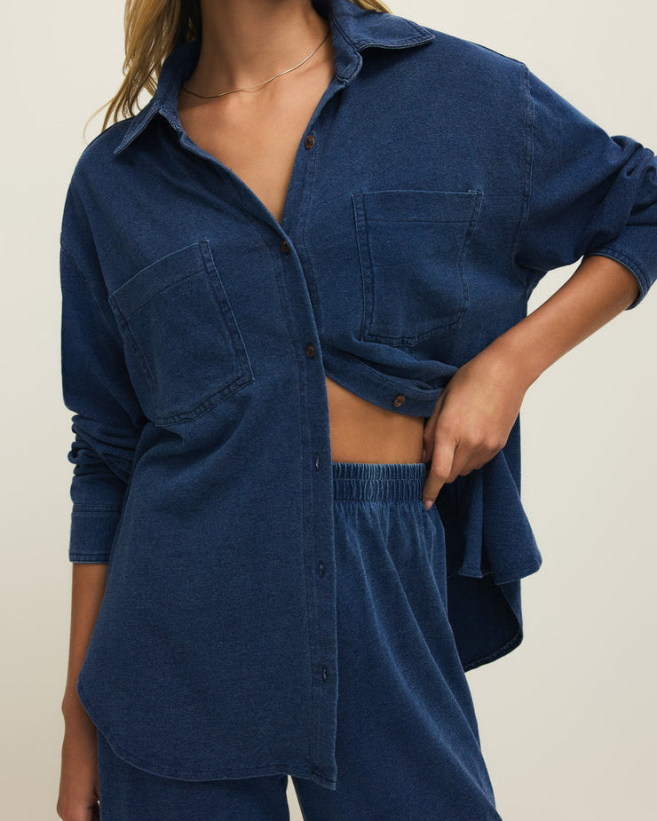 Woman wearing a blue denim outfit on a plain background