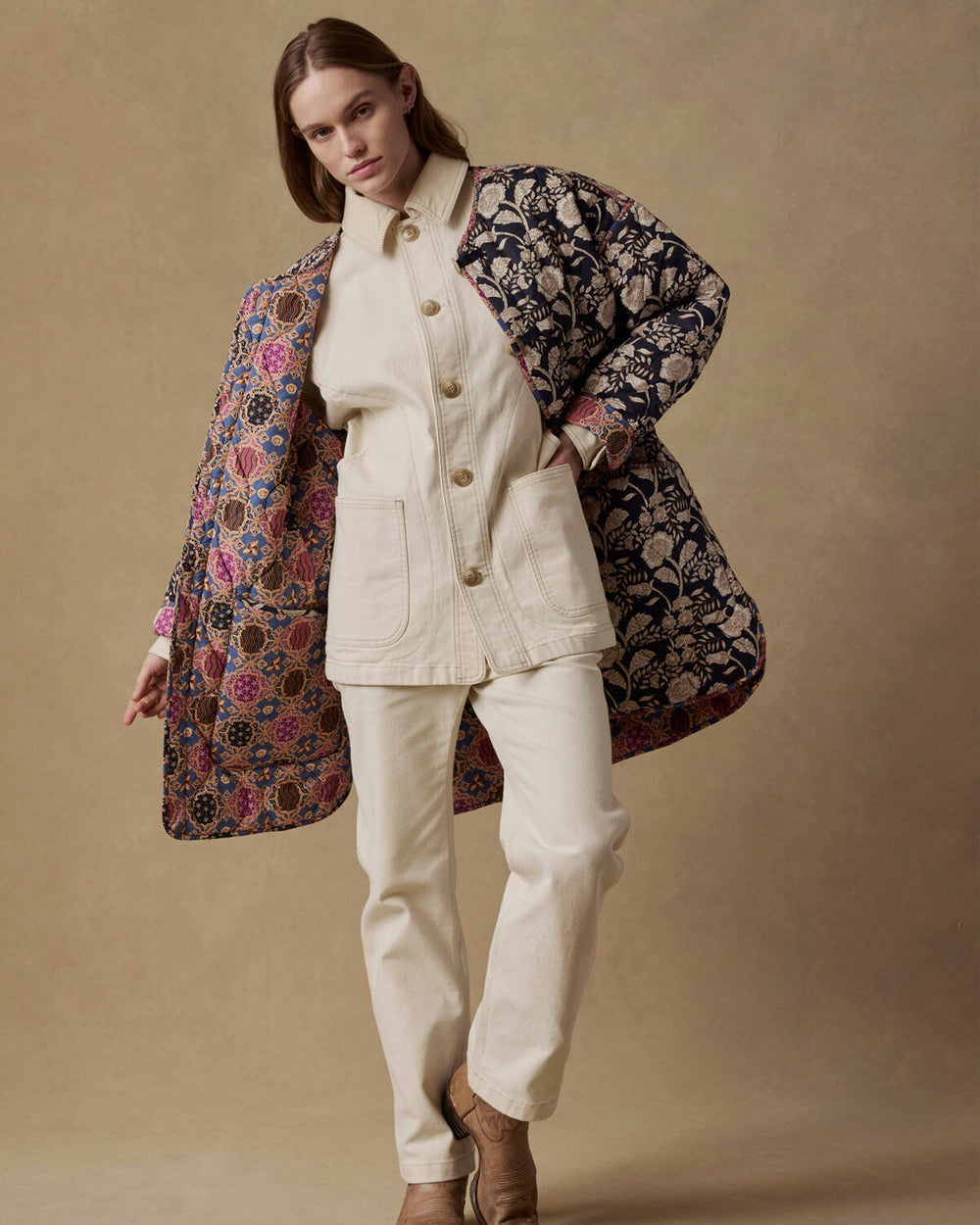 Woman wearing a floral coat over a white outfit on a beige background
