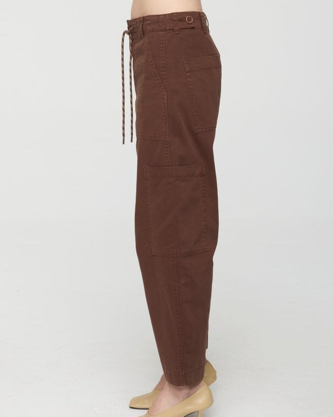 Brown pants worn by a person on a white background