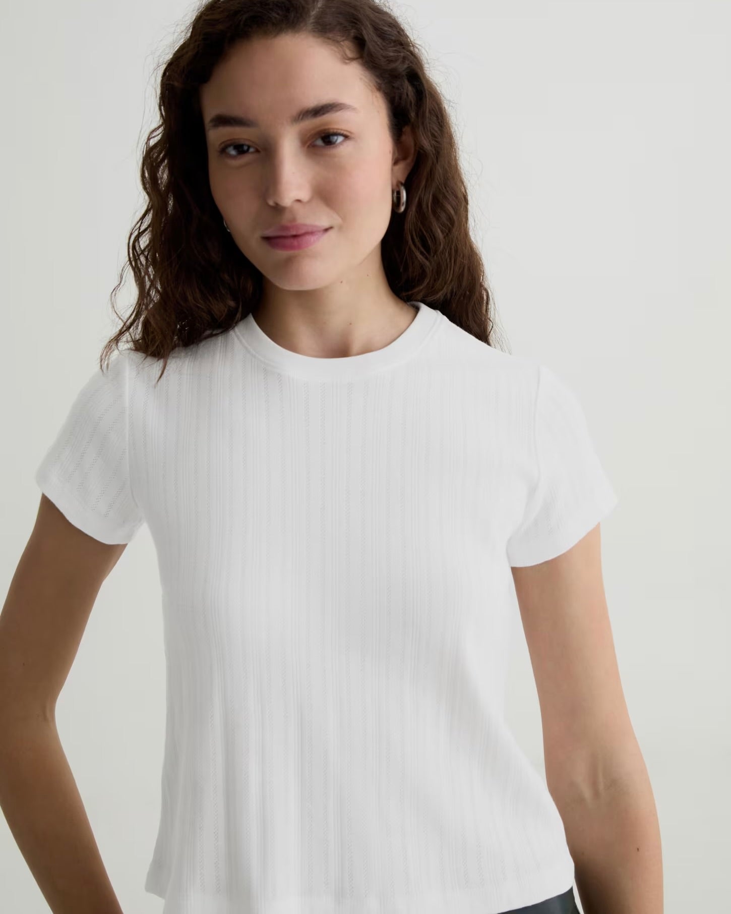 Woman wearing a white t-shirt against a plain background