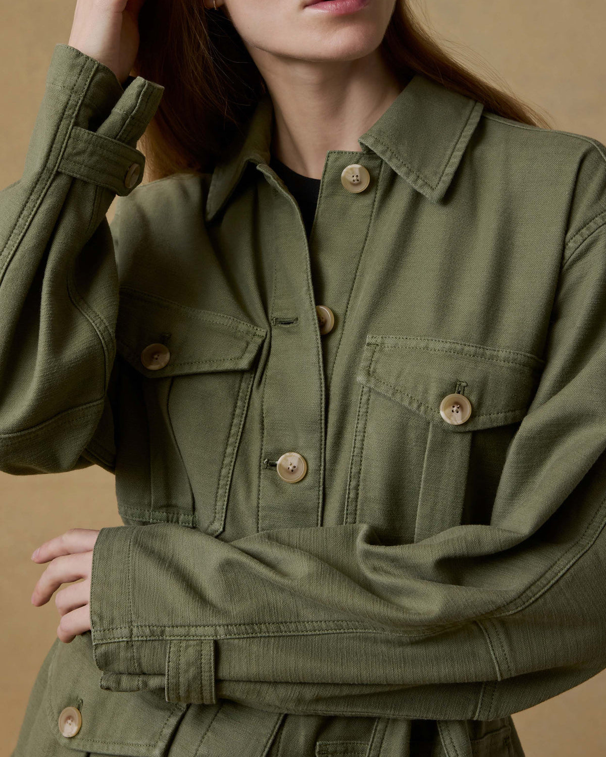 Green jacket worn by a person on a beige background